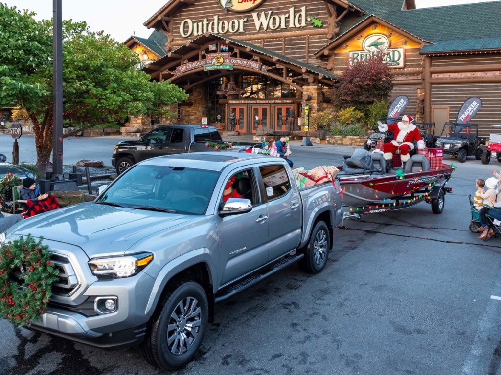 truck pulling Santa on a boat in Bass Pro Shops parking lot