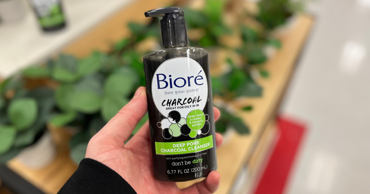 biore charcoal wash in hand above plants