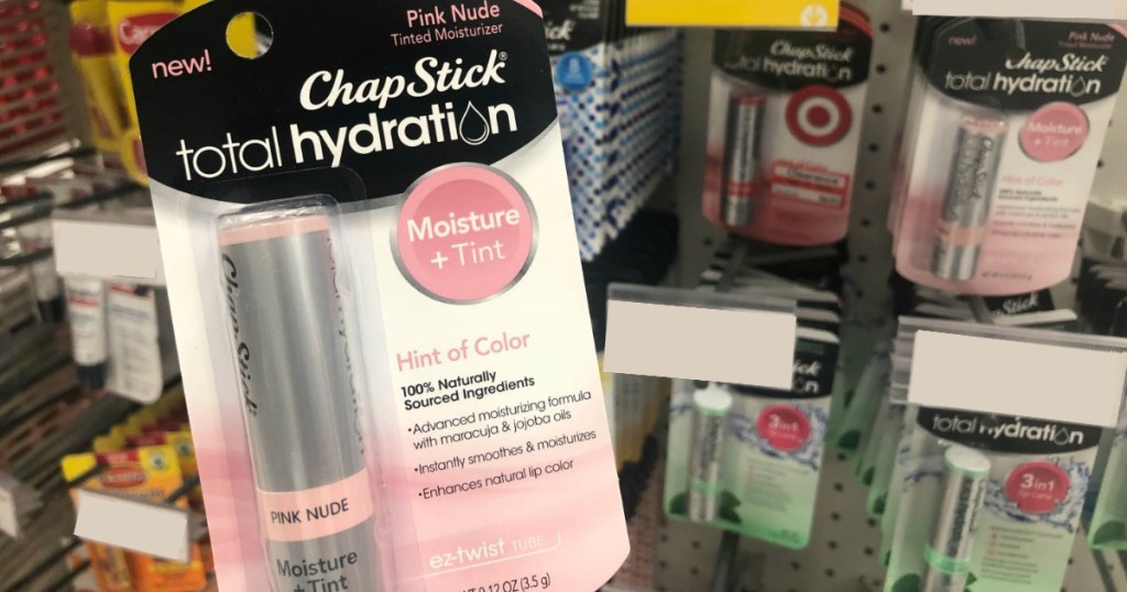 package of chapstick behind held in front of a store shelf