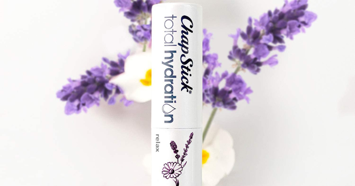 relaxing chaptick tube in front of white and purple flowers