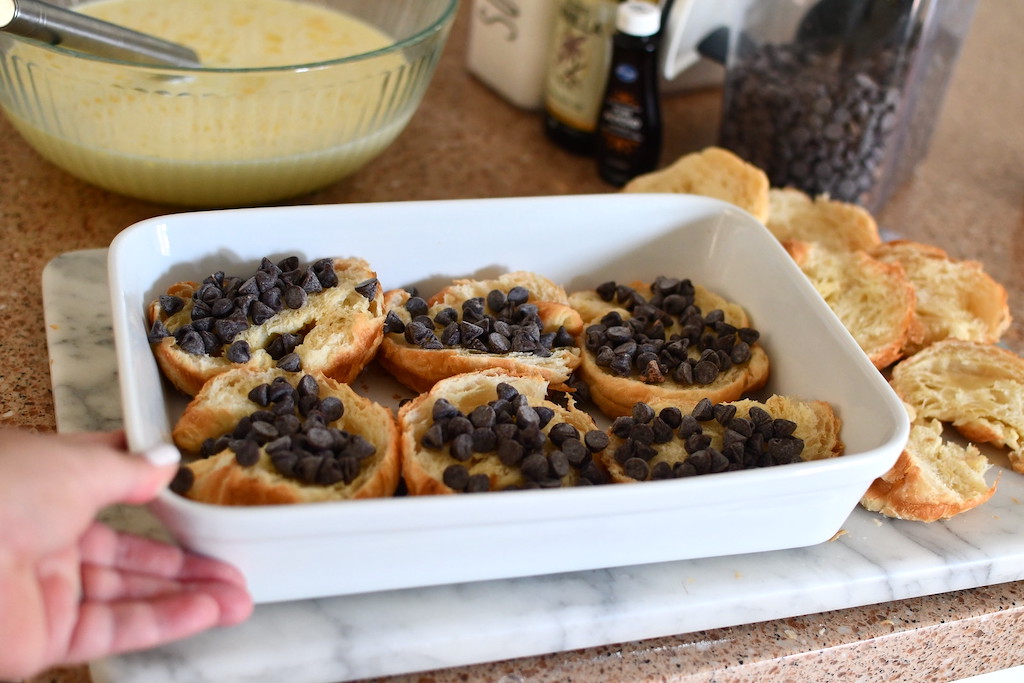 chocolate chips on croissants in casserole dish 