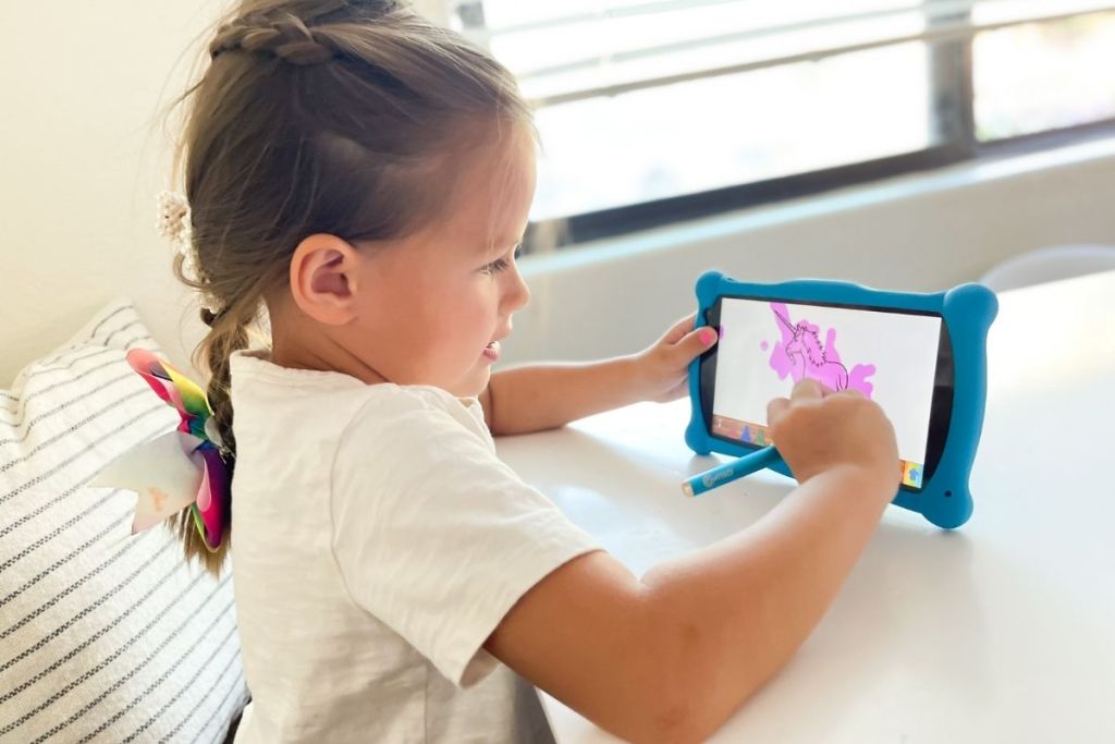 little girl drawing a picture on a Contixo tablet