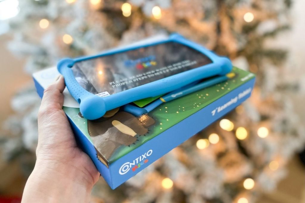 Contixo tablet and box held in front of Christmas tree