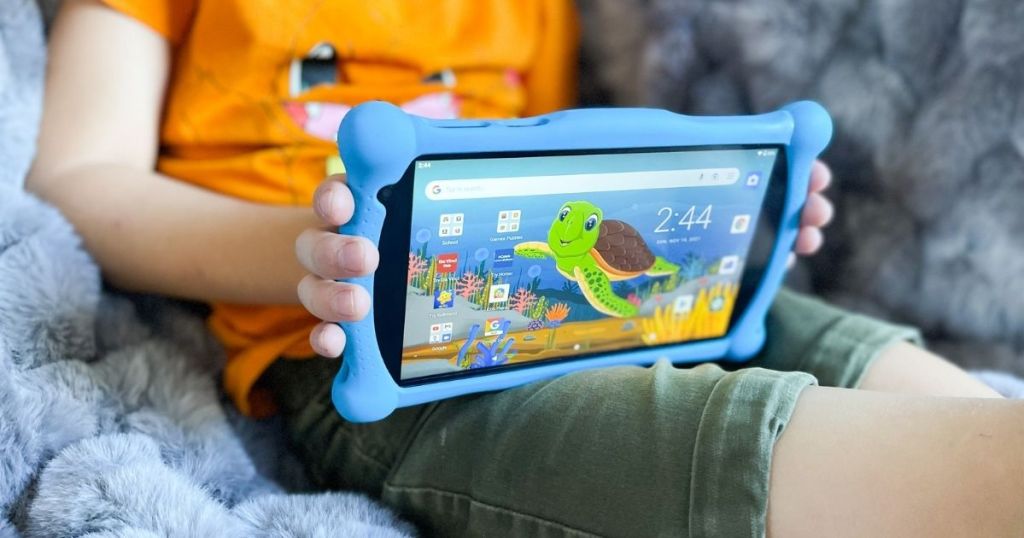 child holding Contixo tablet in their lap