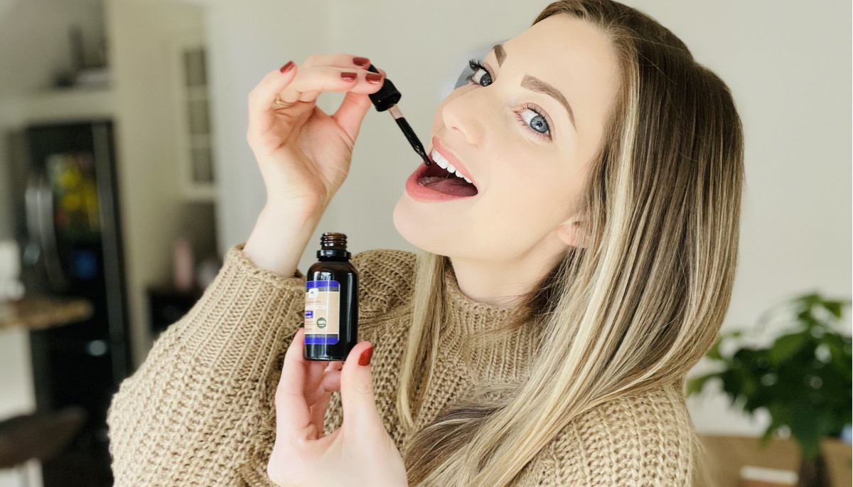 Woman taking drops of elderberry syrup