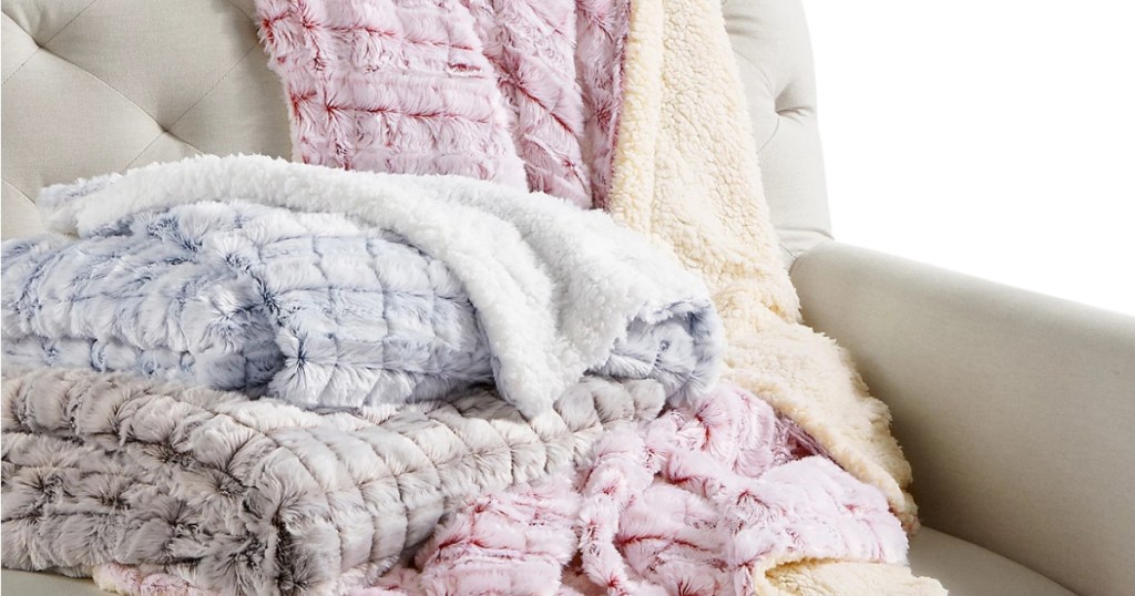 stack of plush throw blankets on a couch
