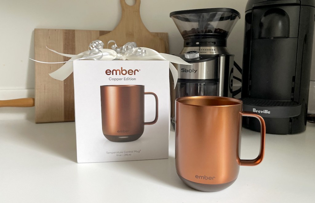copper ember mug and box with bow on kitchen counter with coffee appliances in background - gift ideas people who are always cold