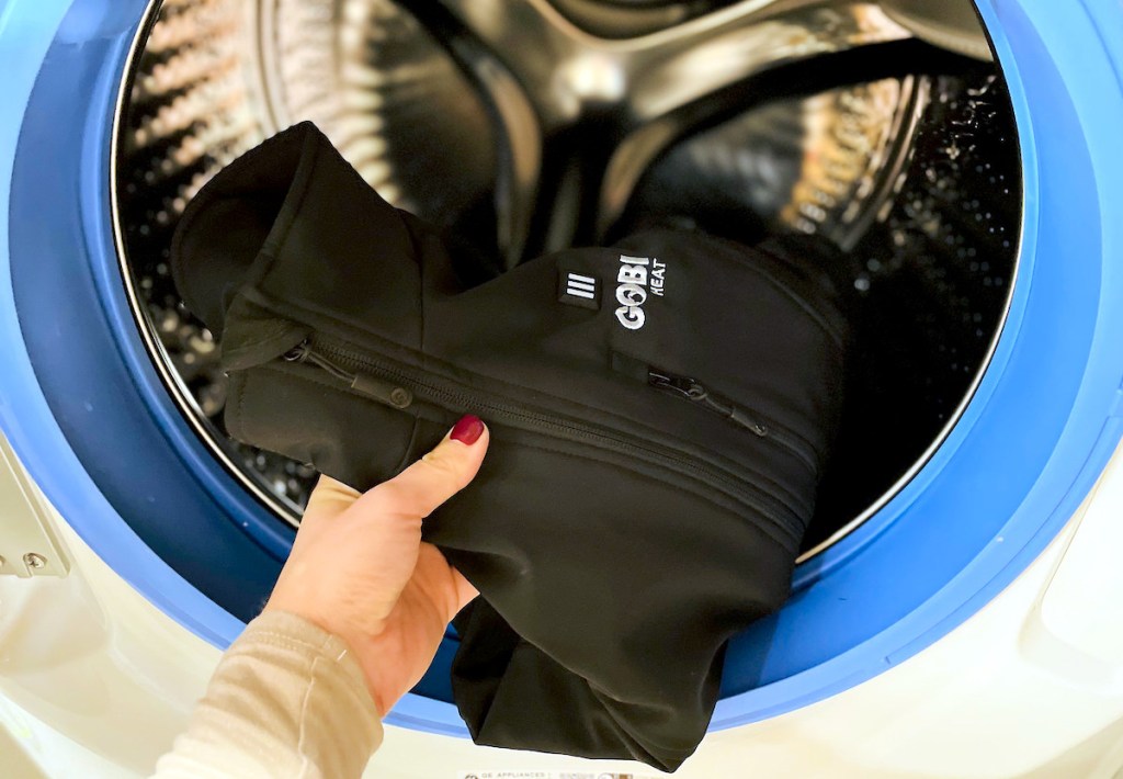 hand holding gobi heat heated jacket inside front load washing machine