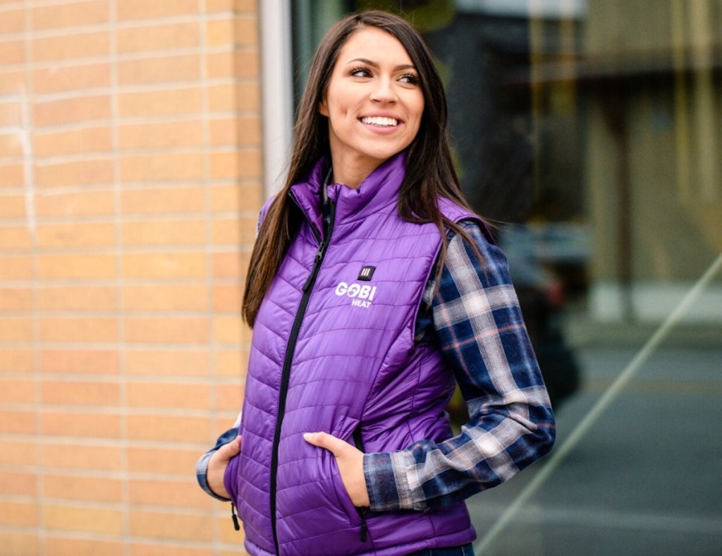 woman with hands in pockets wearing bright purple vest