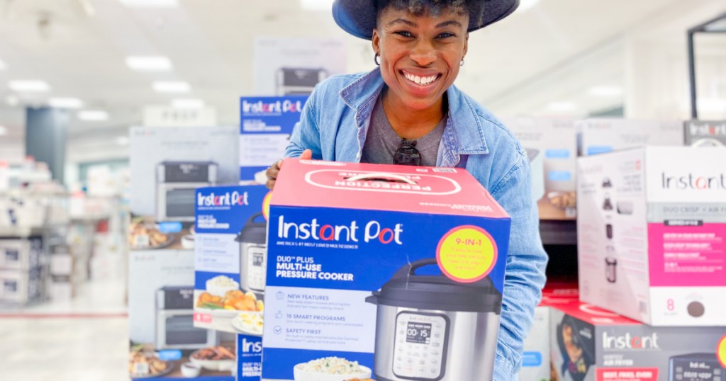 woman holding box in store containing instant pot