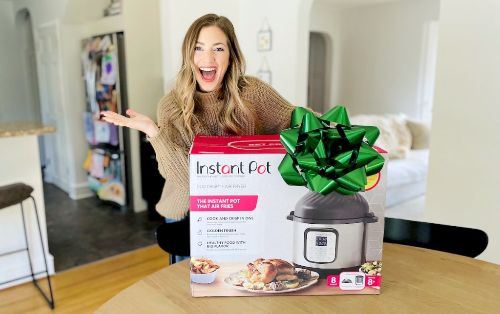 woman standing with huge instant pot box with big green bow