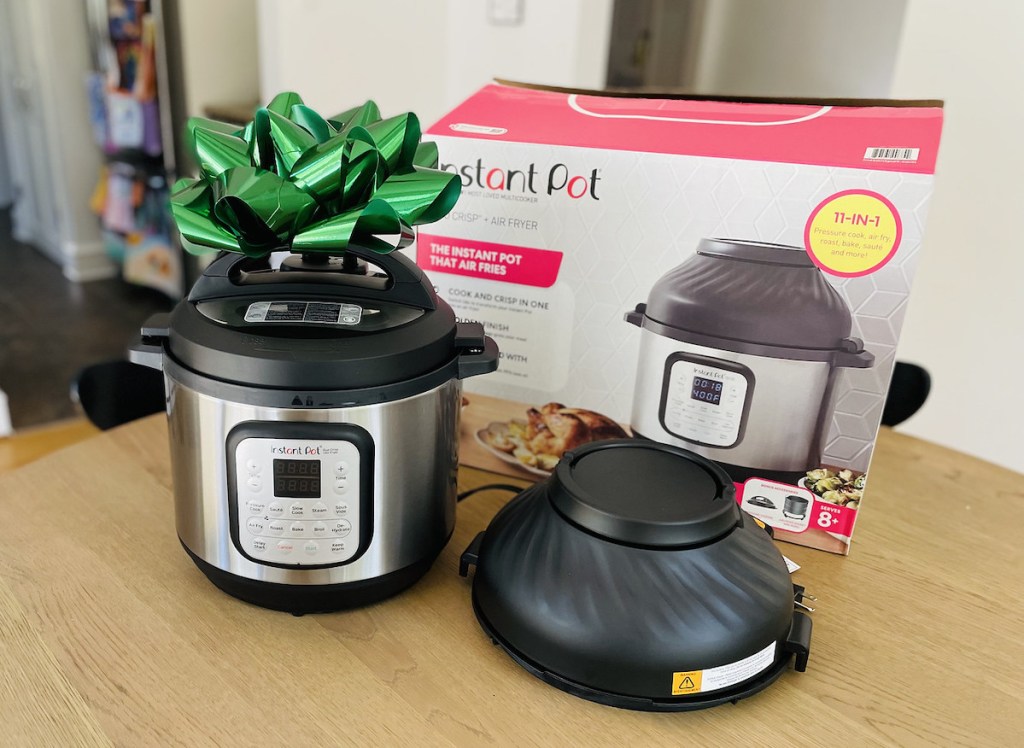 instant pot air fryer sitting on table with big green bow and box