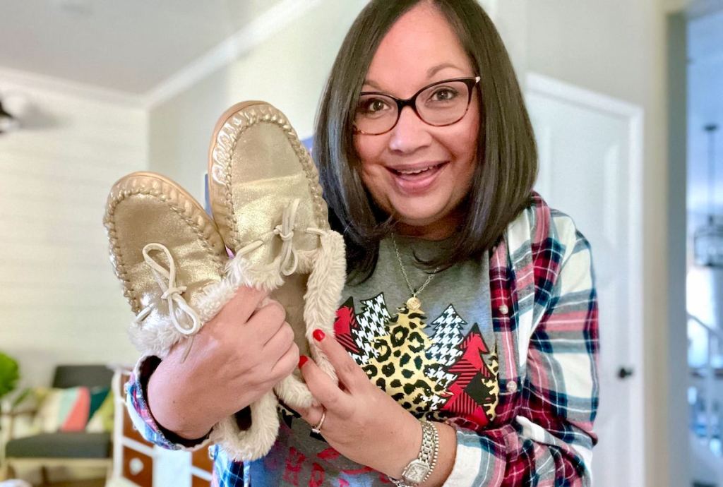 woman holding pair of metallic gold slippers - gift ideas people who are always cold