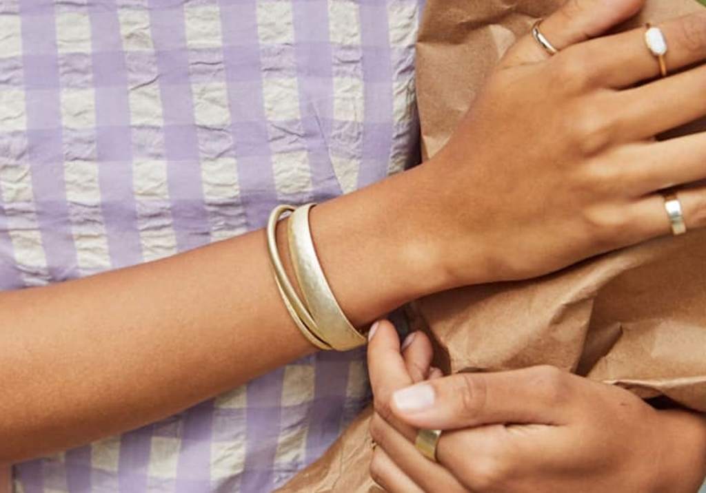 close up of person wearing gold bracelets