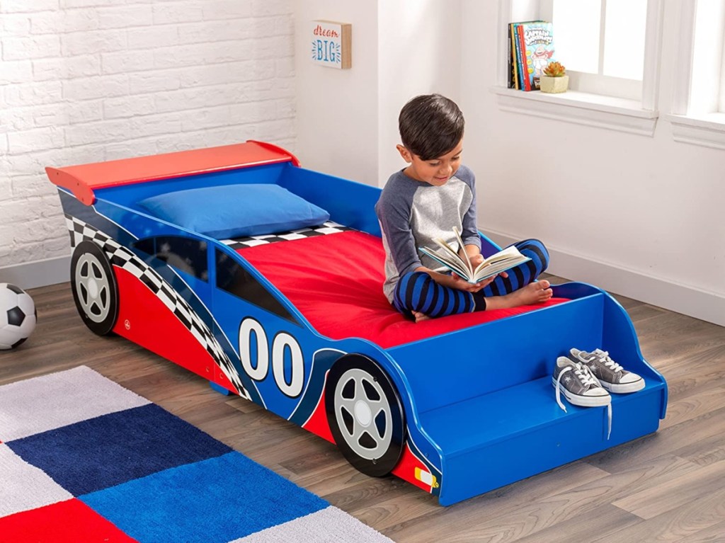 boy reading on racecar bed