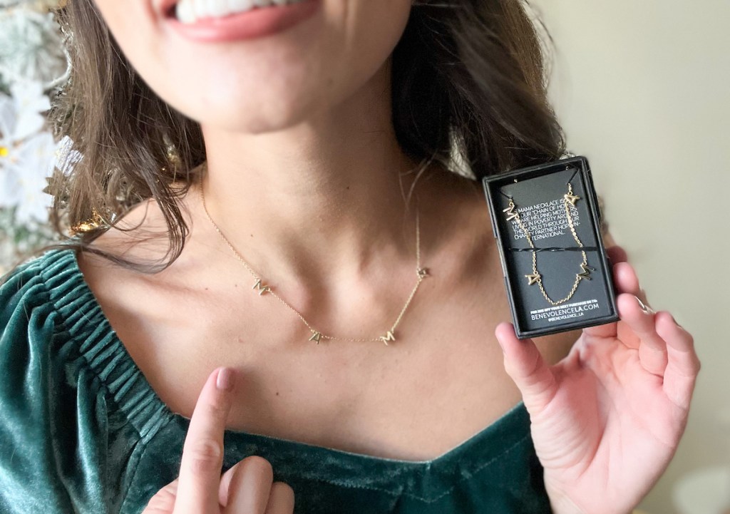 woman wearing mama gold necklace holding box with new necklace inside