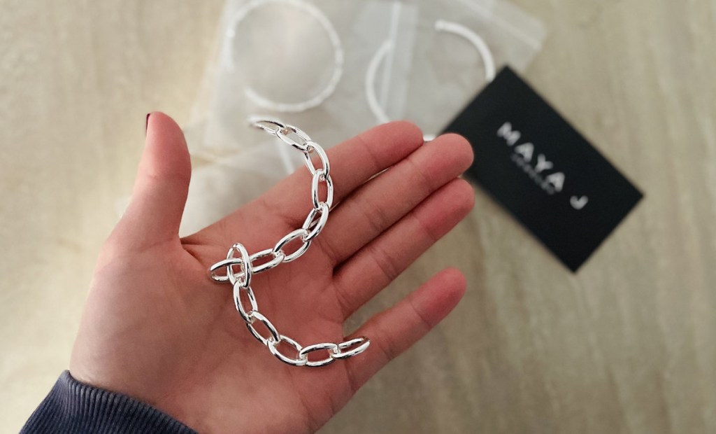 hand holding a broken silver chain link bracelet in palm - oprah's favorite things