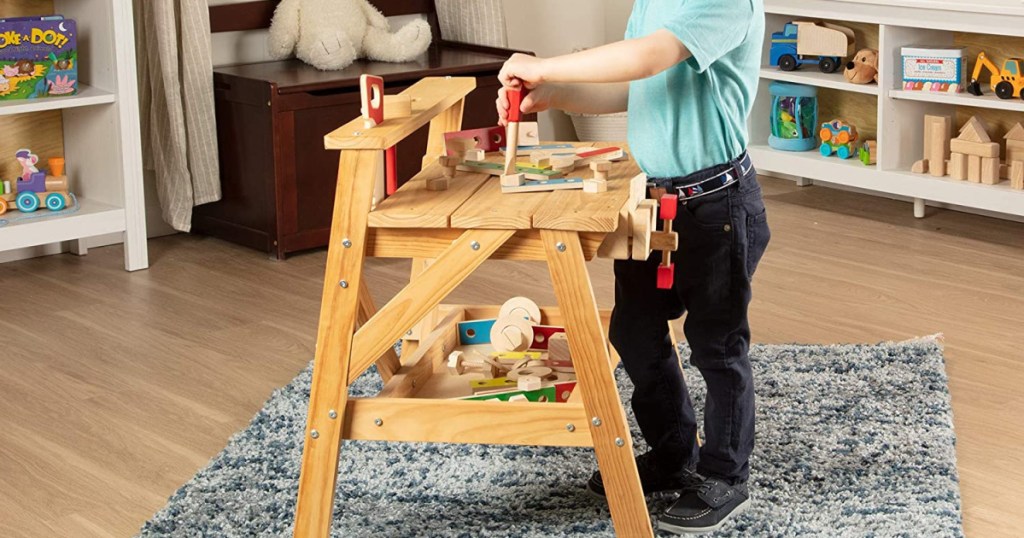 boy playing with a small wooden workbench set