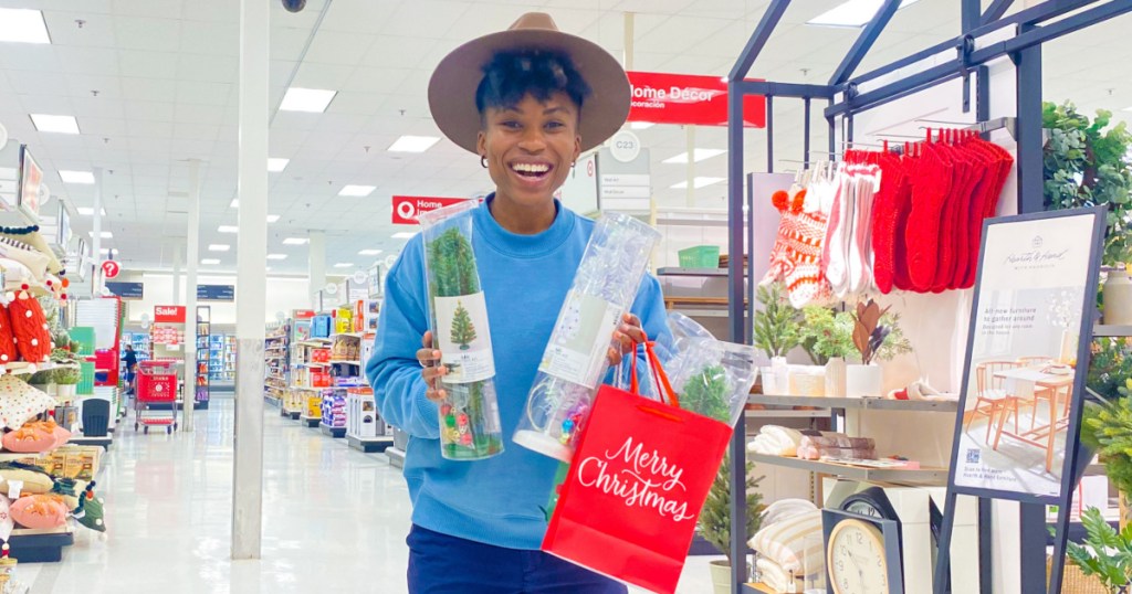 woman holding Christmas decor items in-store
