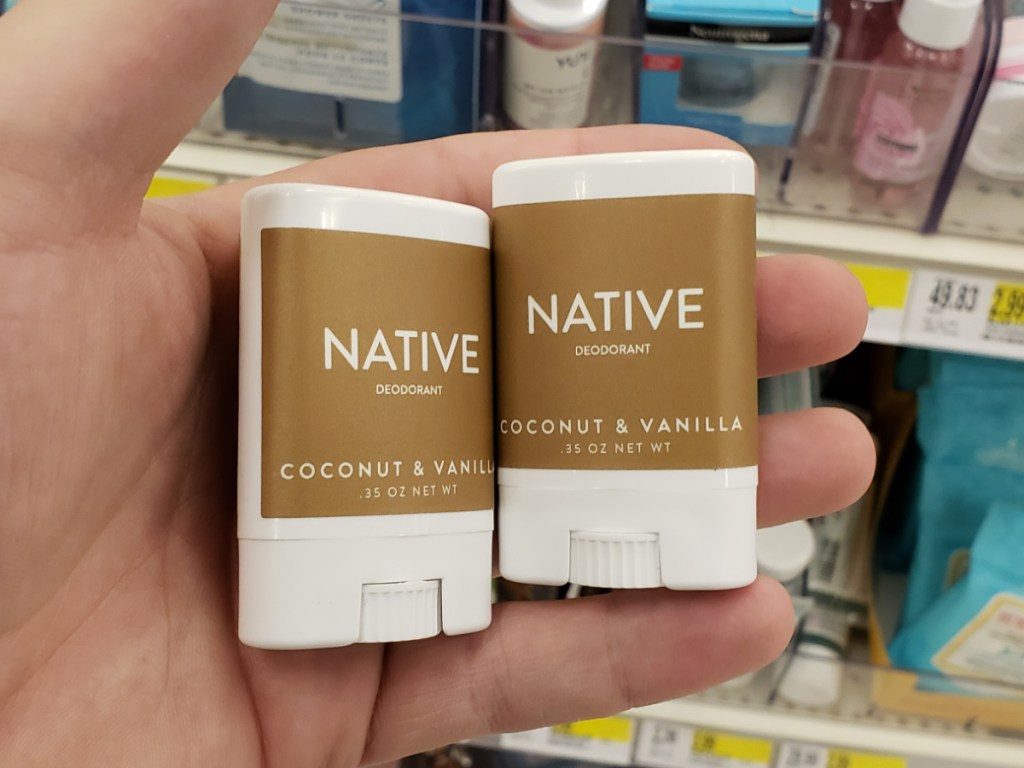 hand holding 2 small containers of deodorant in store