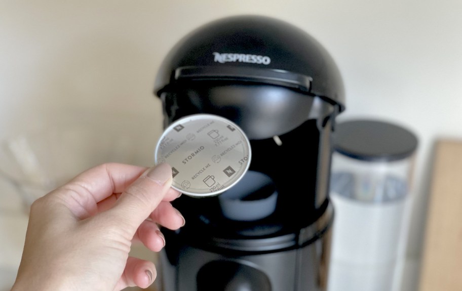 hand putting nespresso pod into coffee machine