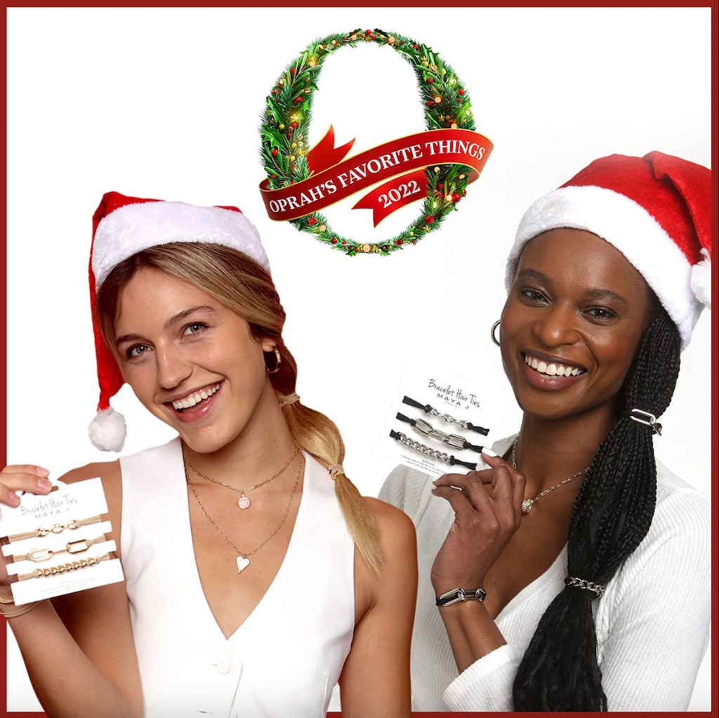 two women holding up oprahs favorite things list products wearing santa hats