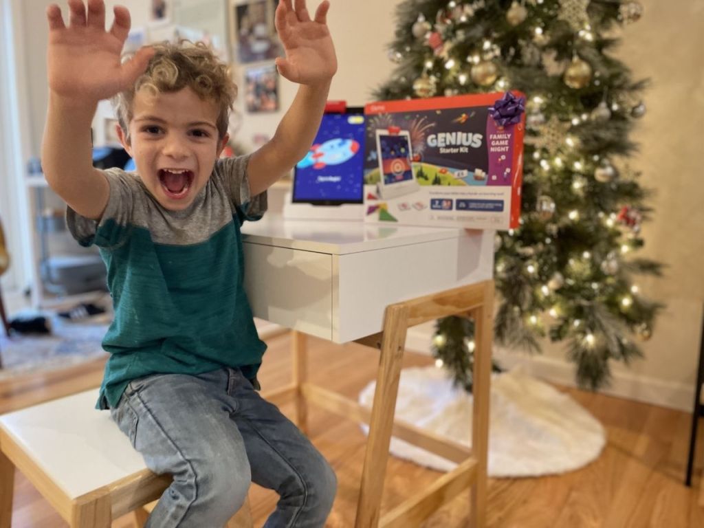 kid raising his hands laughing in front of Osmo kit