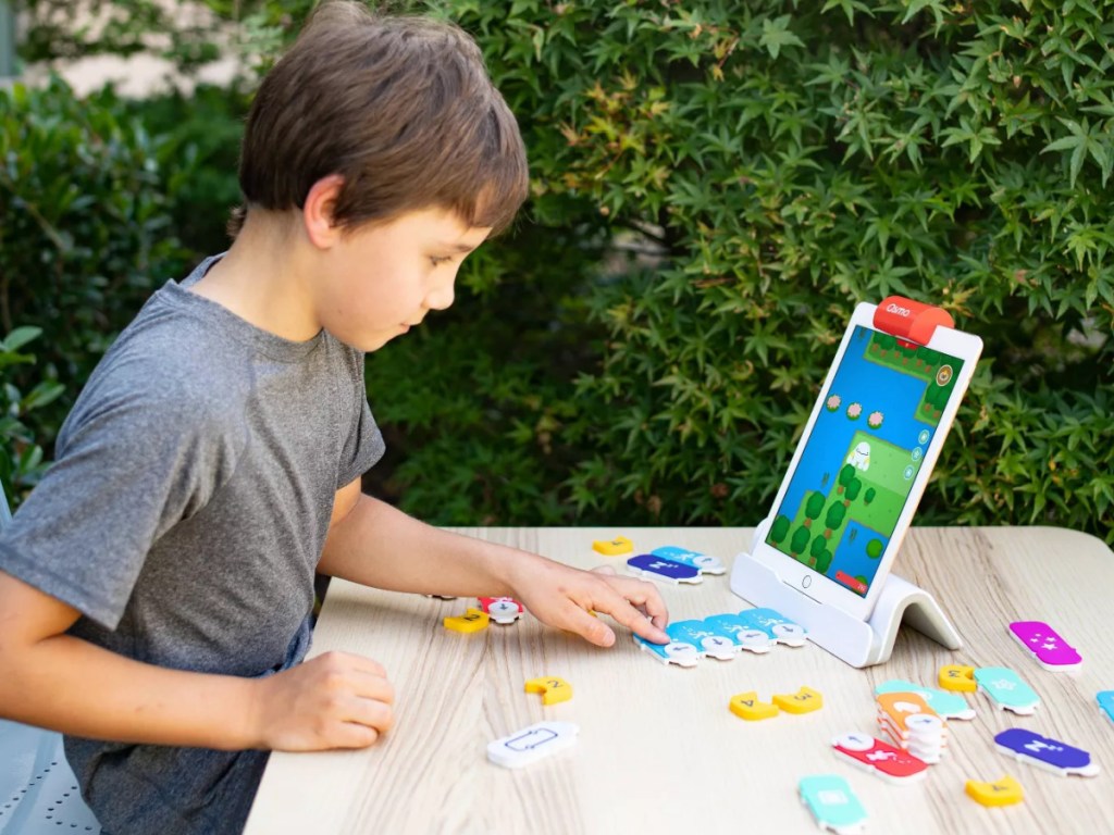 Osmo - Coding Starter Kit for iPad - Ages 5-12 - Coding STEM boy sitting at table using ipad