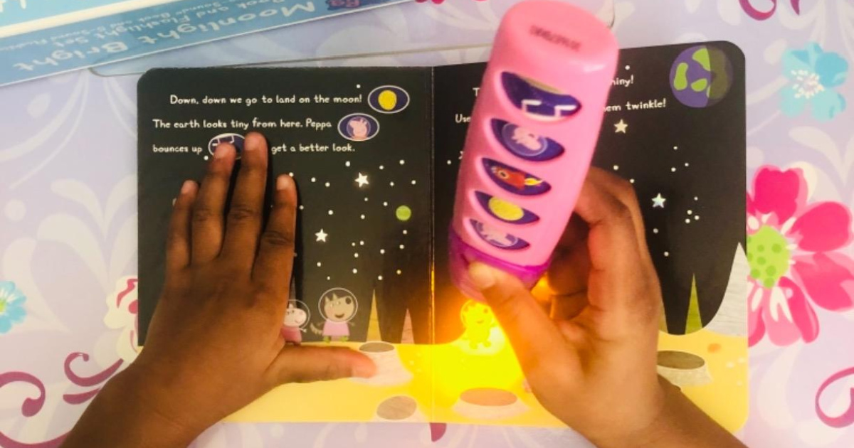 child using a toy flashlight with a book