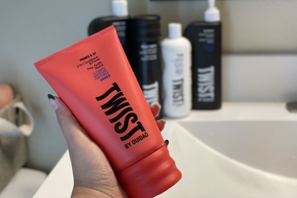 Holding a bottle of Twist's Primed & Co conditioner