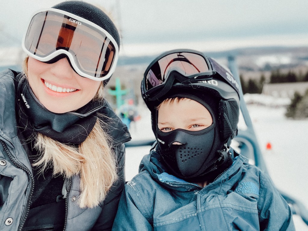 mom and son on ski lift on mountain