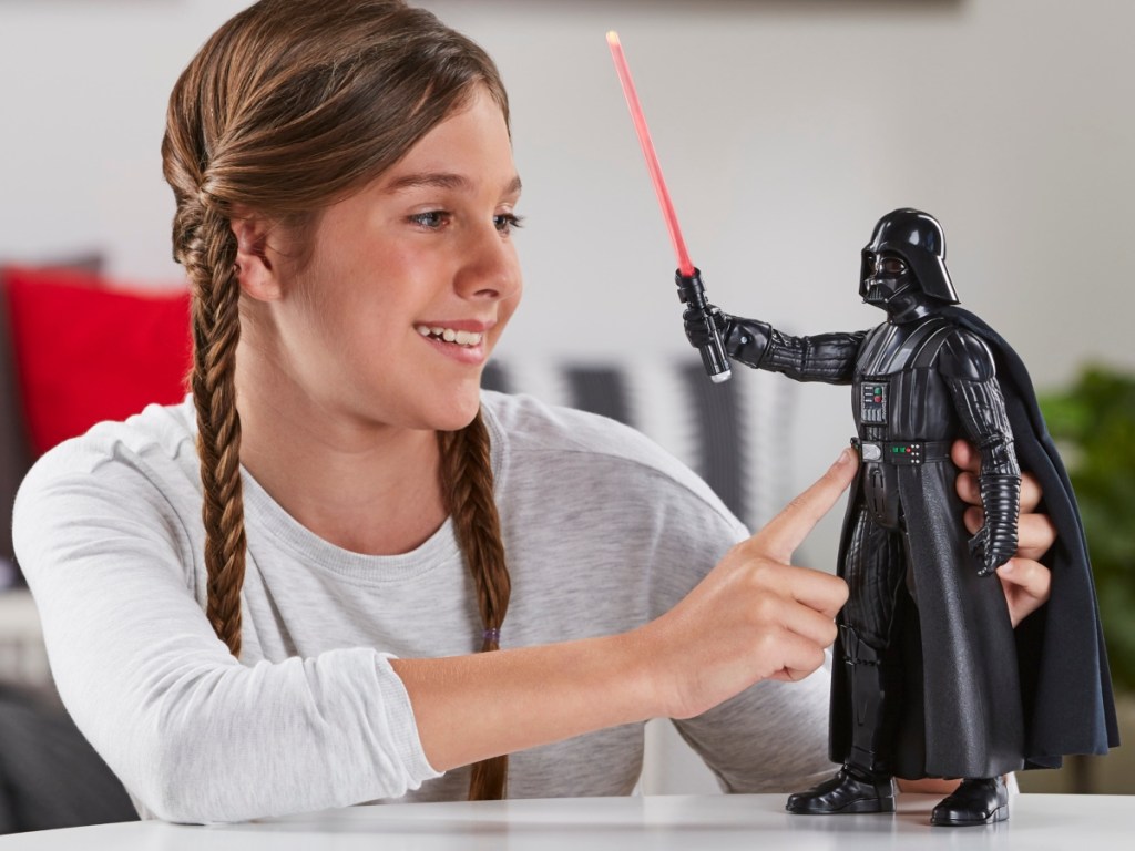 girl playing with Darth Vader action figure
