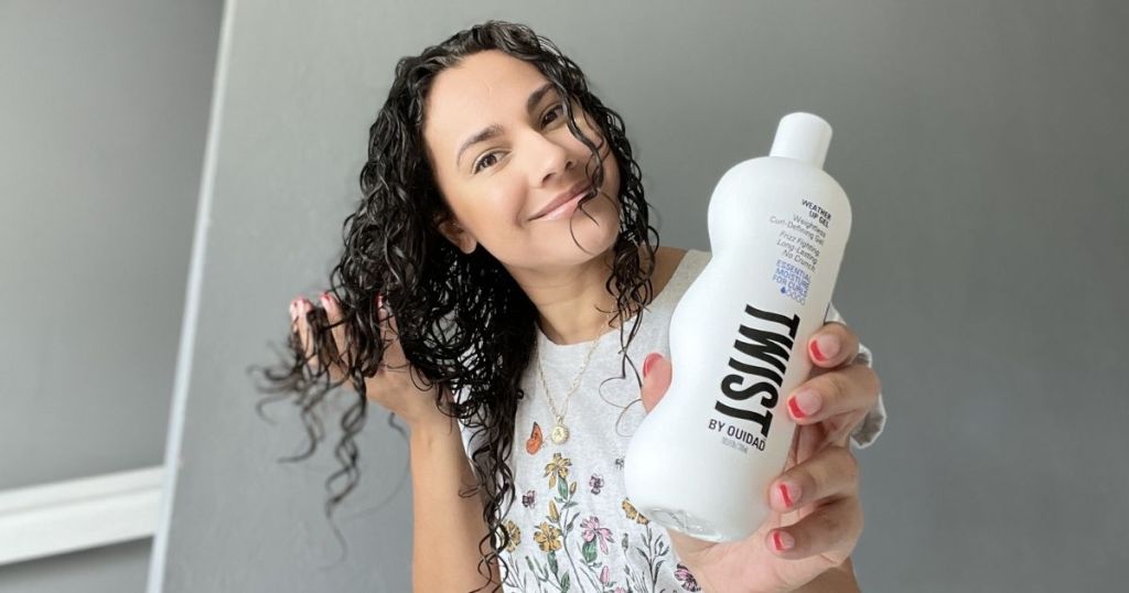 woman holding bottle of Twist by Ouidad curly hair product