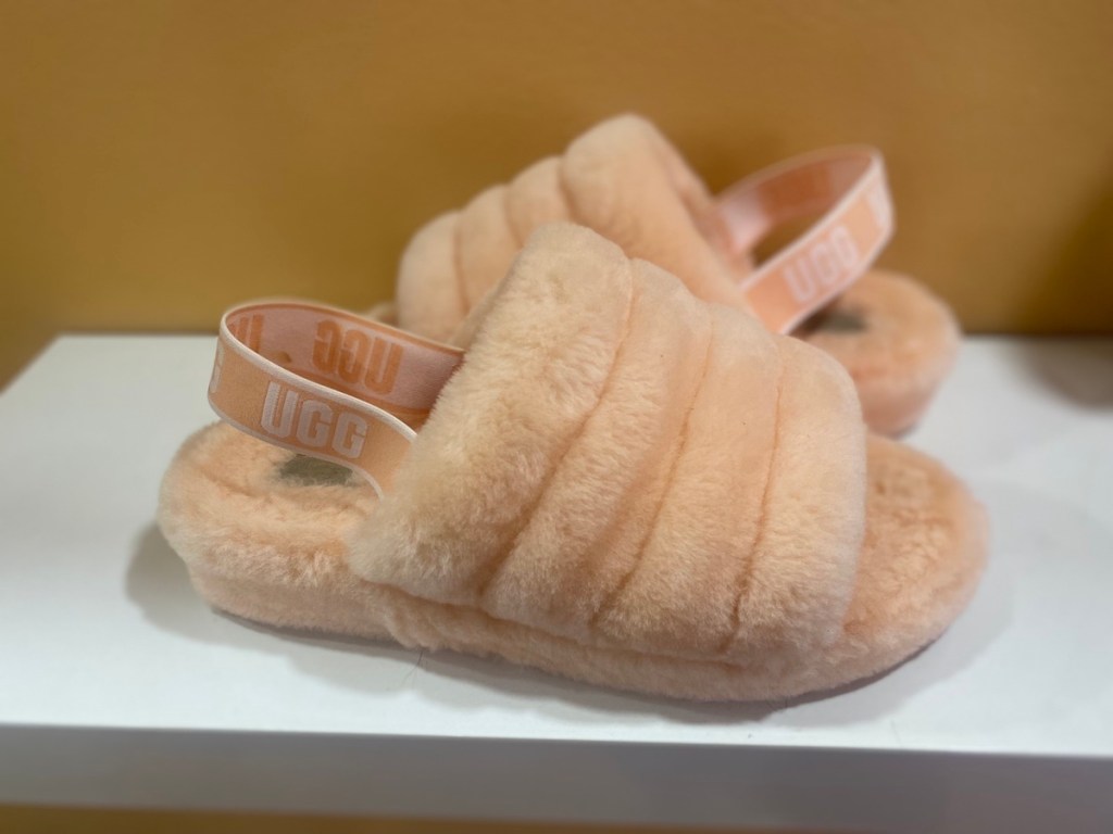 peach colored ugg slippers on white box