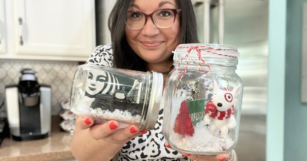 woman holding gift card snow globes