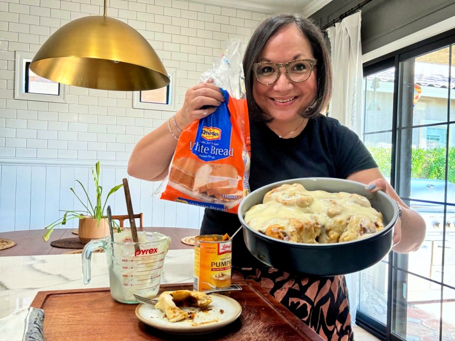 woman holding pumpkin cinnamon rolls and frozen bread dough