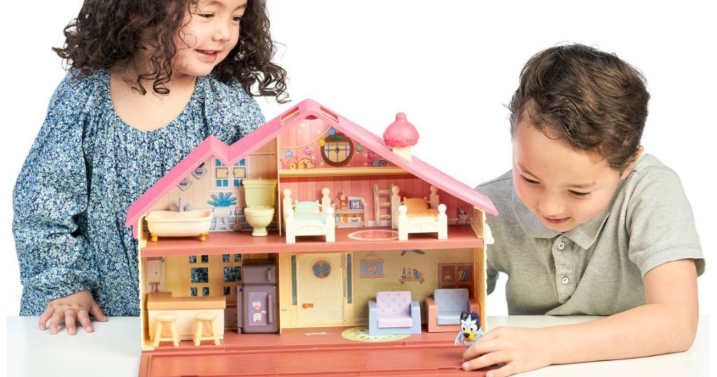 Two children playing with Bluey house playset