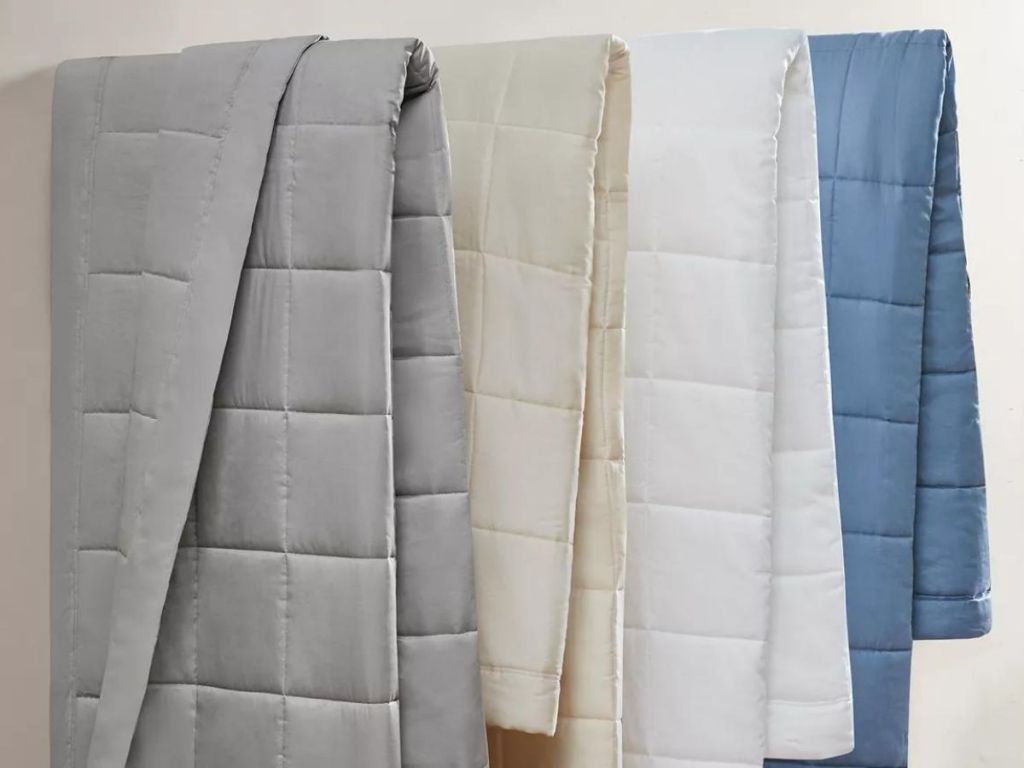 gray, off-white, white, and blue comforters hanging side by side