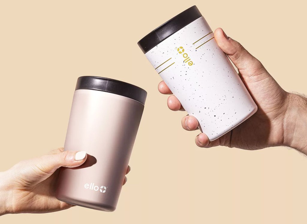 two hand holding tumblers