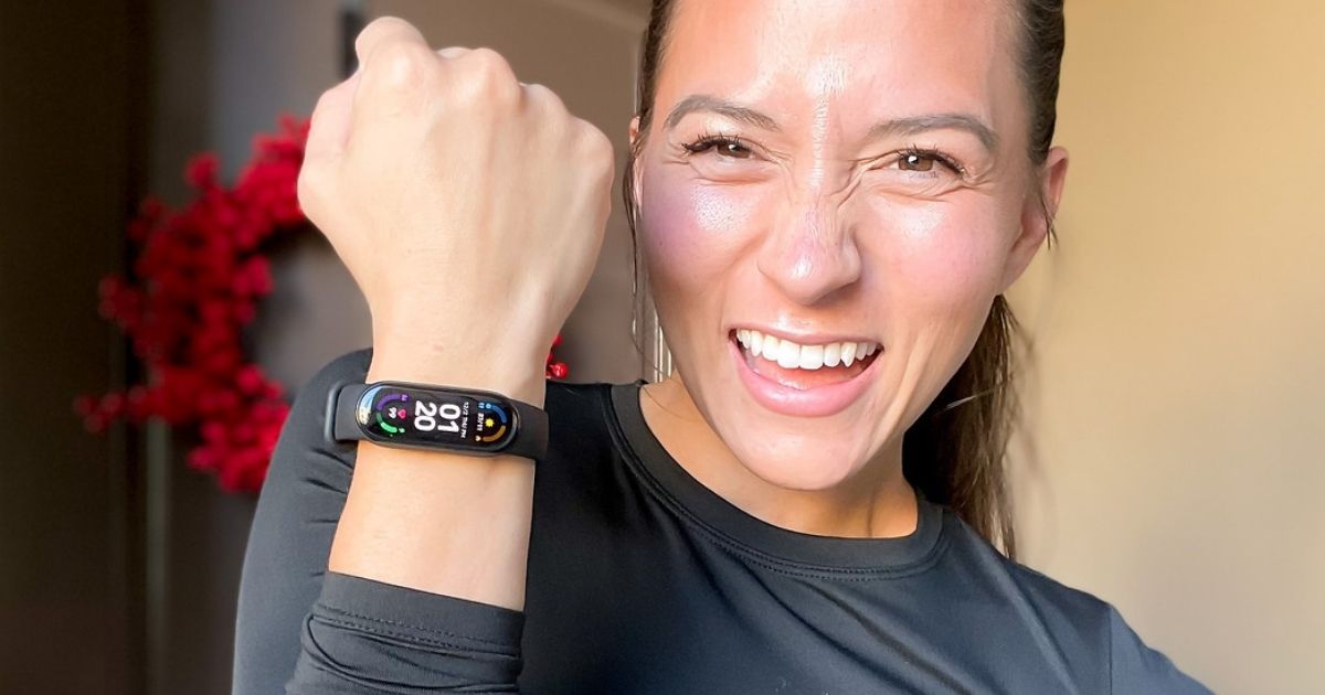 woman holding up her wrist with a fitness tracker on it 