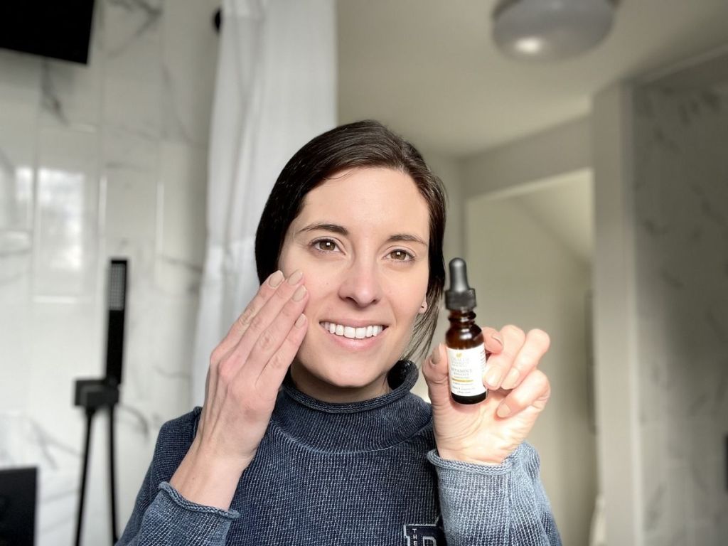 woman putting Health Priority Vitamin E Oil on her face