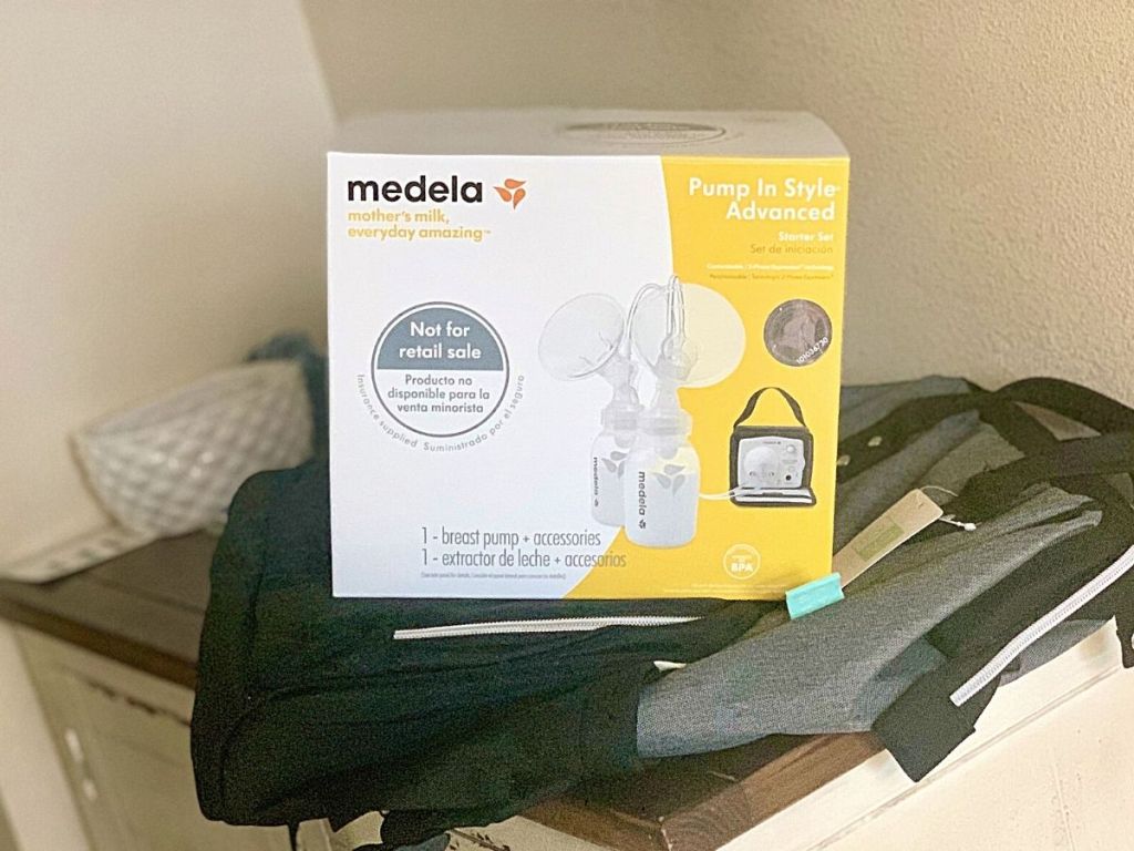 Medela breast pump sitting on backpack diaper bag on table