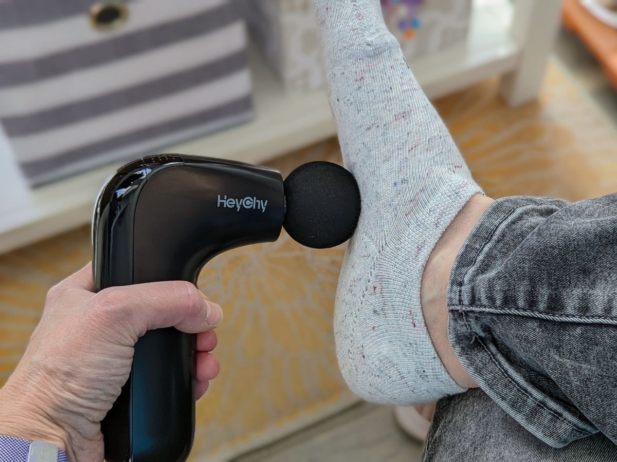 person using HeyChy Mini Massage Gun on foot