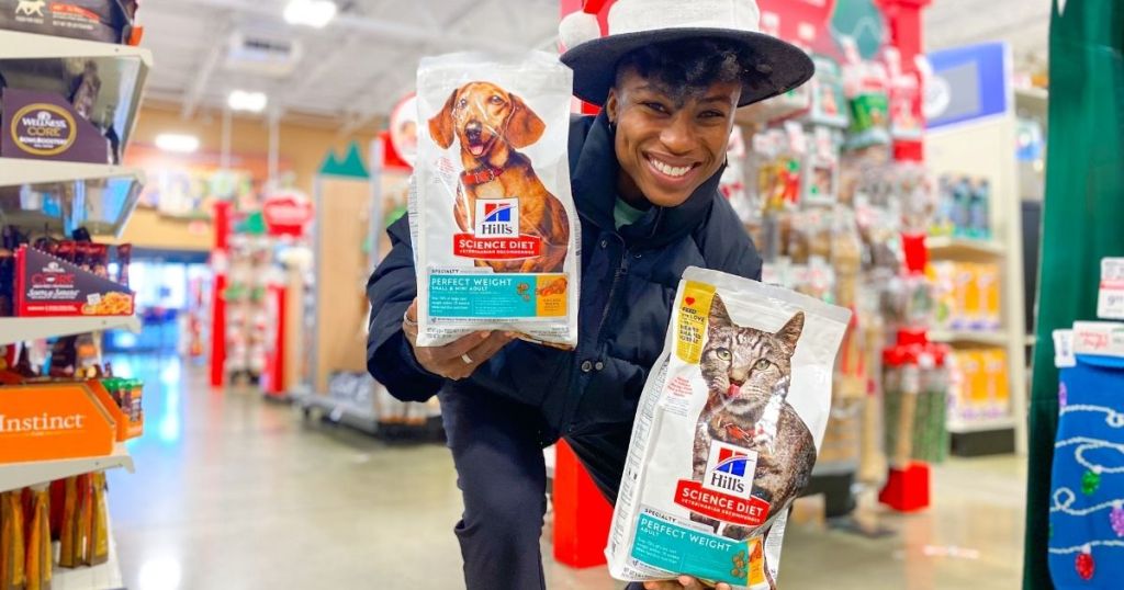 person holding Hill's dog food and cat food