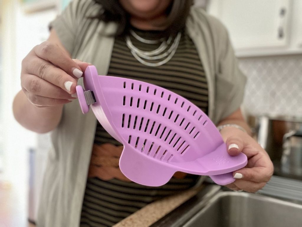 woman holding purple Kitchen Gizmo Snap N Strain Adjustable Silicone Cup