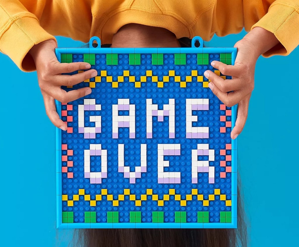 person holding a LEGO Dots Message Board