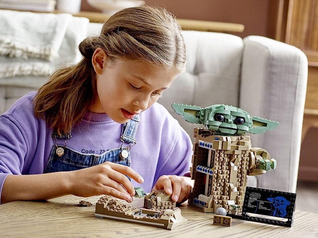 girl building LEGO Star Wars The Mandalorian The Child Set