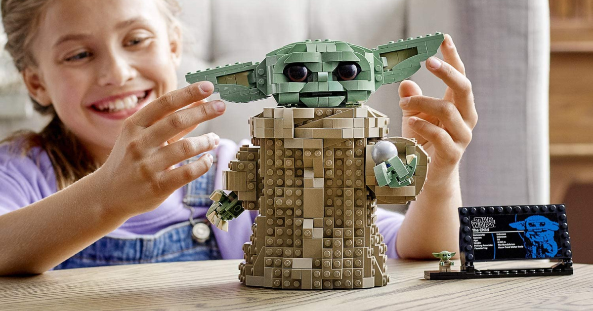 little girl playing with a yoda lego set