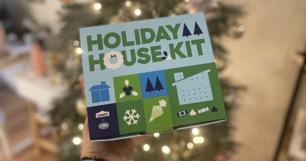 Person holding box containing Lowe's Holiday House Kit