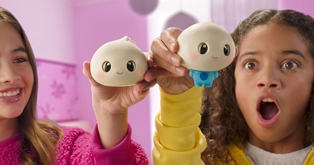 two girls holding dumpling character toys